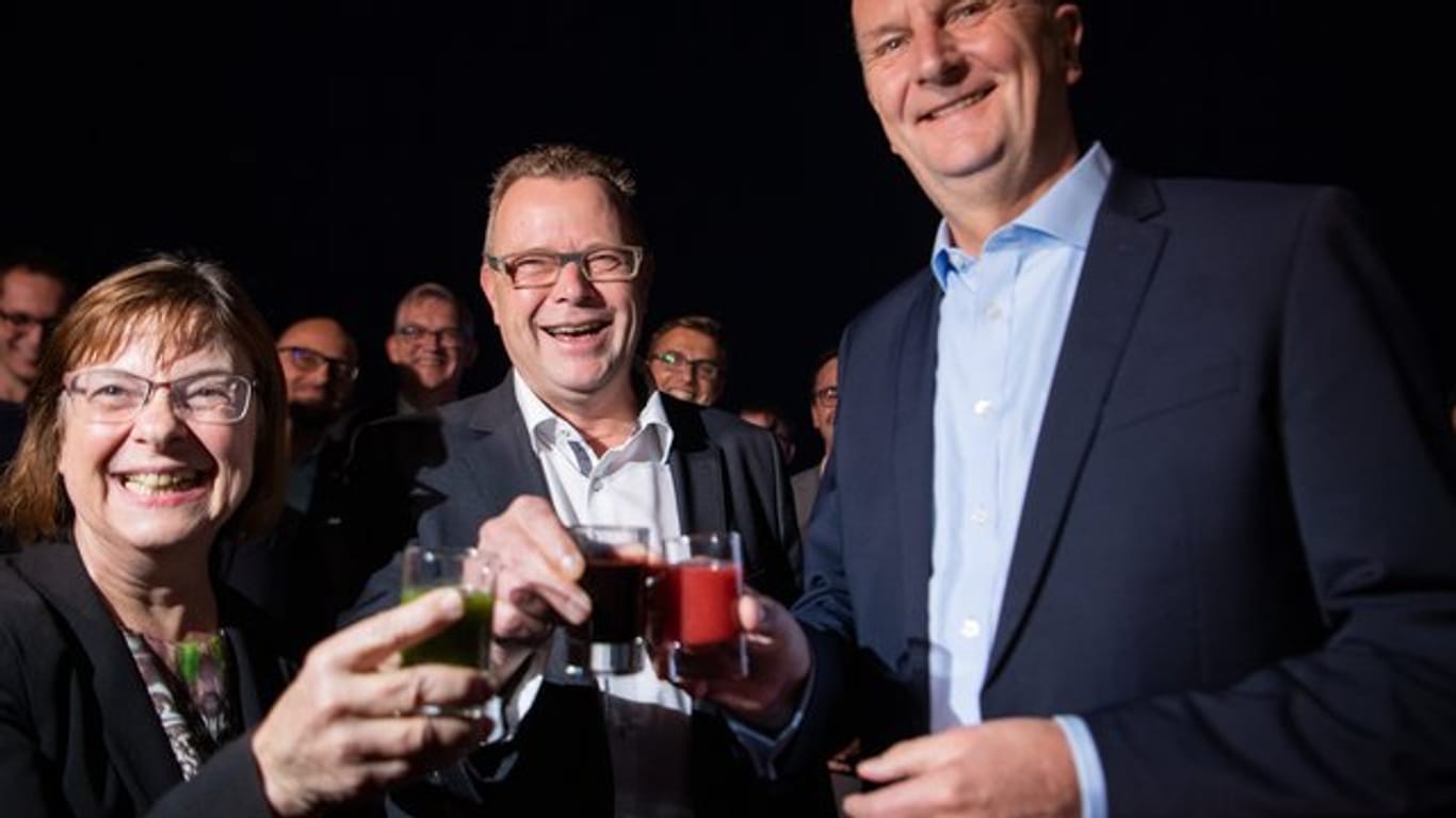 Ursula Nonnemacher von den Grünen (l), Michael Stübgen von der CDU (M) und Ministerpräsident Dietmar Woidke (SPD, r) stoßen auf ihre künftige Koalition an.