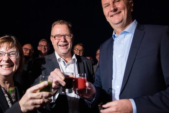 Ursula Nonnemacher von den Grünen (l), Michael Stübgen von der CDU (M) und Ministerpräsident Dietmar Woidke (SPD, r) stoßen auf ihre künftige Koalition an.