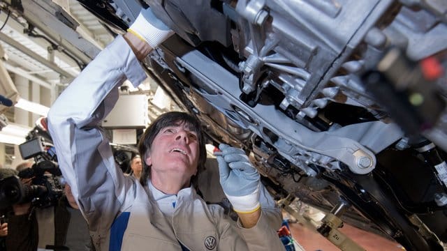 Joachim Löw einen Gelenkenwellenschutz an einen neuen Volkswagen Golf 8.