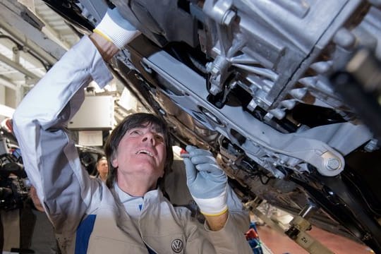 Joachim Löw einen Gelenkenwellenschutz an einen neuen Volkswagen Golf 8.