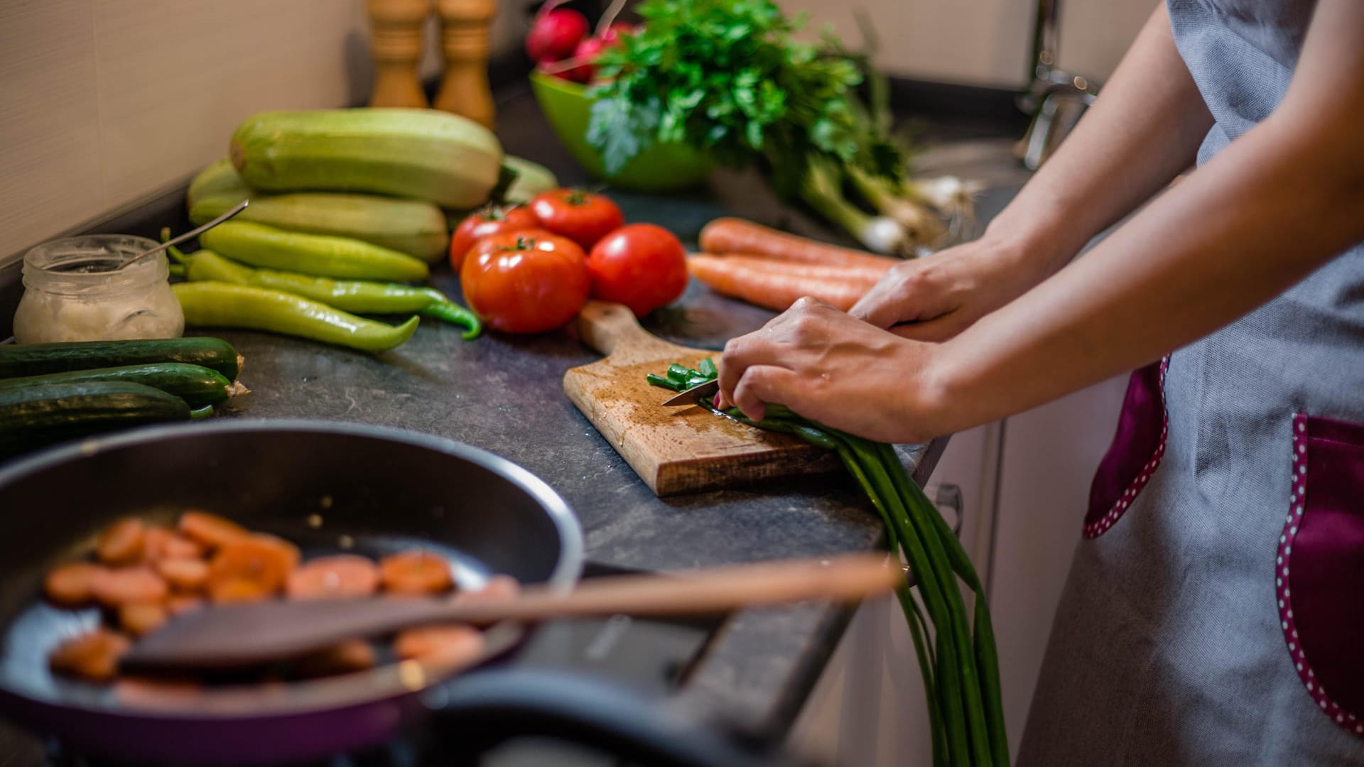 Eine Frau bereitet Essen zu: Die richtige Ernährung kann das Risiko für Herzerkrankungen senken.