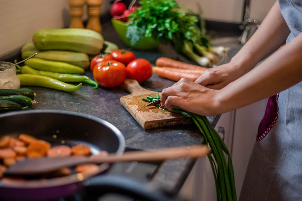 Eine Frau bereitet Essen zu: Die richtige Ernährung kann das Risiko für Herzerkrankungen senken.