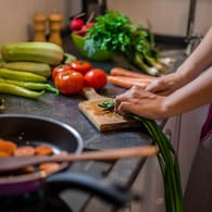 Eine Frau bereitet Essen zu: Die richtige Ernährung kann das Risiko für Herzerkrankungen senken.