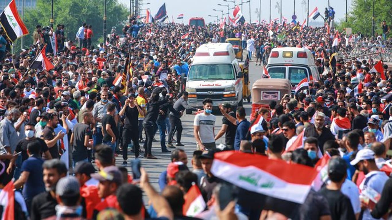 Regierungsfeindliche Demonstranten protestieren auf einer Straße in Bagdad.