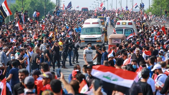 Regierungsfeindliche Demonstranten protestieren auf einer Straße in Bagdad. Regierungsfeindliche Demonstranten protestieren auf einer Straße in Bagdad.