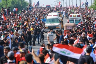 Regierungsfeindliche Demonstranten protestieren auf einer Straße in Bagdad.