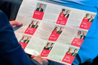 Ein Mann schaut sich die Kandidaten-Duos für den Parteivorsitz der SPD bei der letzten Regionalkonferenz auf einem Flyer an.