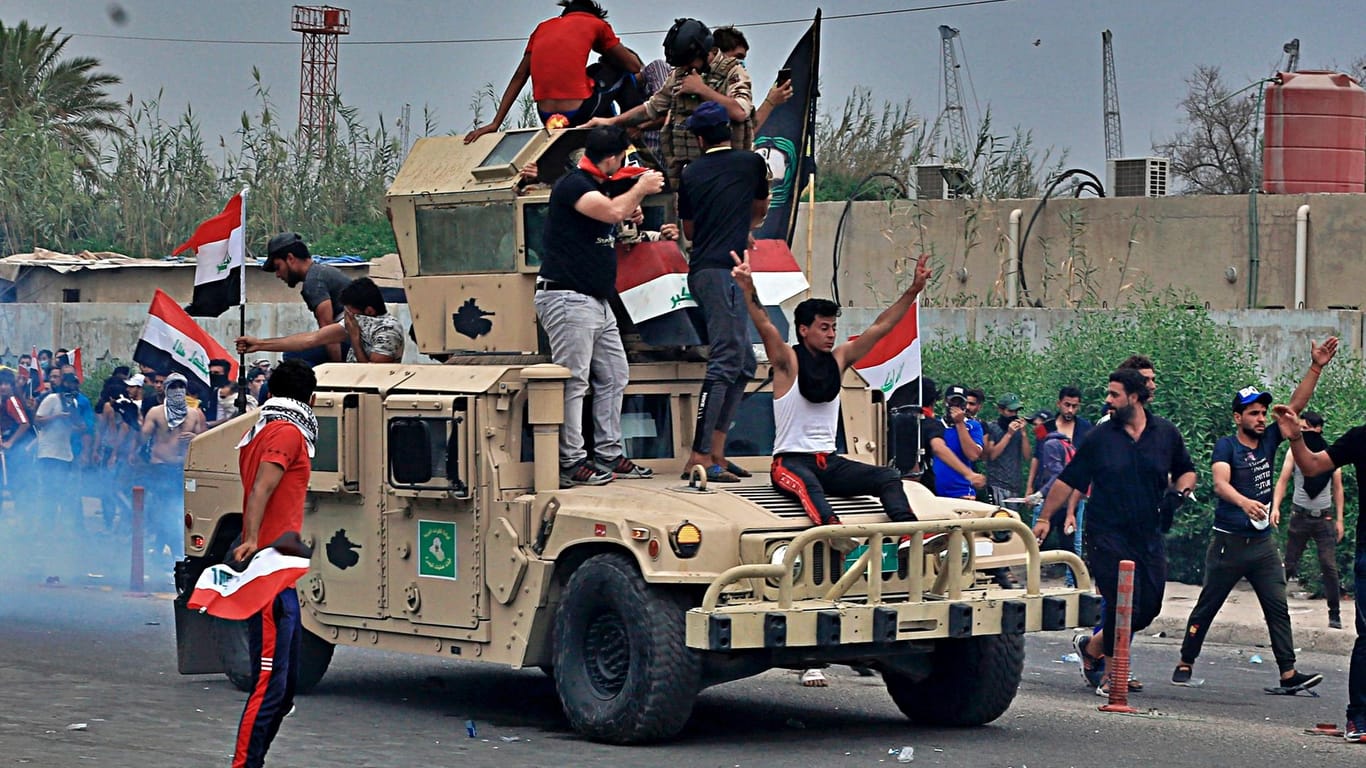 Proteste im Irak: Die Demonstranten demolieren einen Militärjeep.