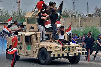 Proteste im Irak: Die Demonstranten demolieren einen Militärjeep.
