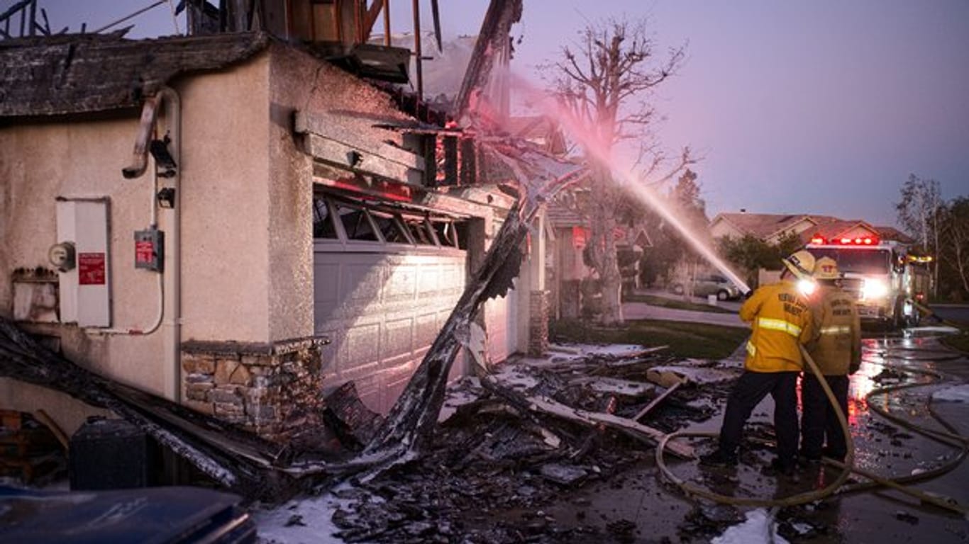 Feuerwehrleute löschen ein brennendes Haus im südkalifornischen Santa Clarita.