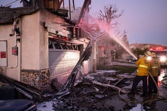 Feuerwehrleute löschen ein brennendes Haus im südkalifornischen Santa Clarita.