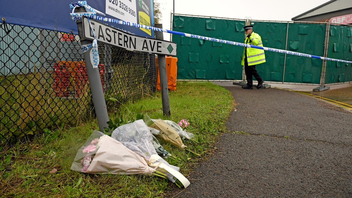 Blumensträuße liegen nahe des Fundortes der 39 Leichen: Die Polizei nahm bislang vier Verdächtige fest.