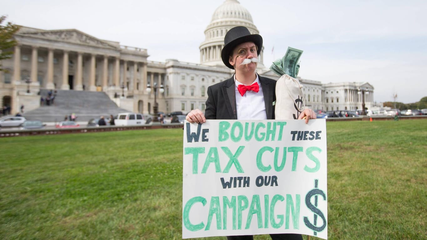 Ein Demonstrant kritisiert die Steuerpolitik Trumps: Kritiker sehen durch die Reformen Reiche und Unternehmen im Vorteil – auf Kosten der Staatsfinanzen.