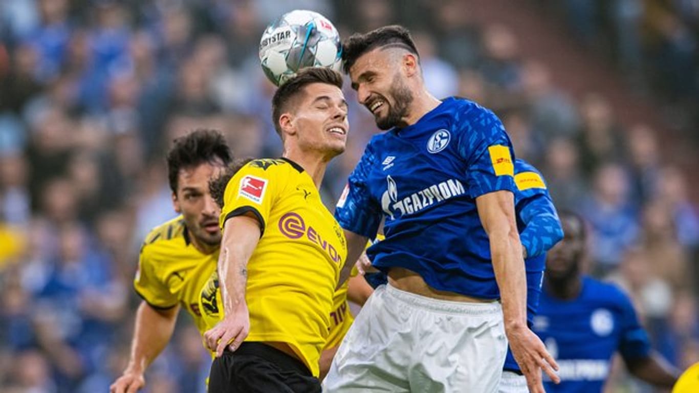 Dortmunds Julian Weigl (l) und Schalkes Daniel Caligiuri kämpfen im Kopfballduell um den Ball.