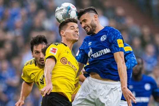 Dortmunds Julian Weigl (l) und Schalkes Daniel Caligiuri kämpfen im Kopfballduell um den Ball.