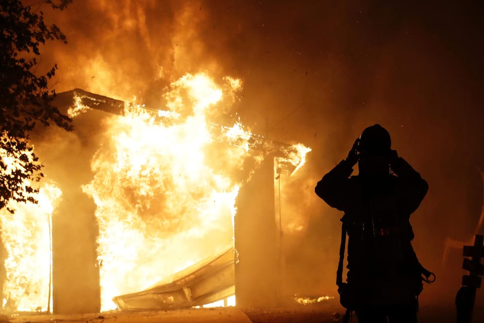 Ein Feuerwehrmann vor einem brennenden Haus in Santa Clarita: Ein schnell um sich greifender Waldbrand tobt in Kalifornien.