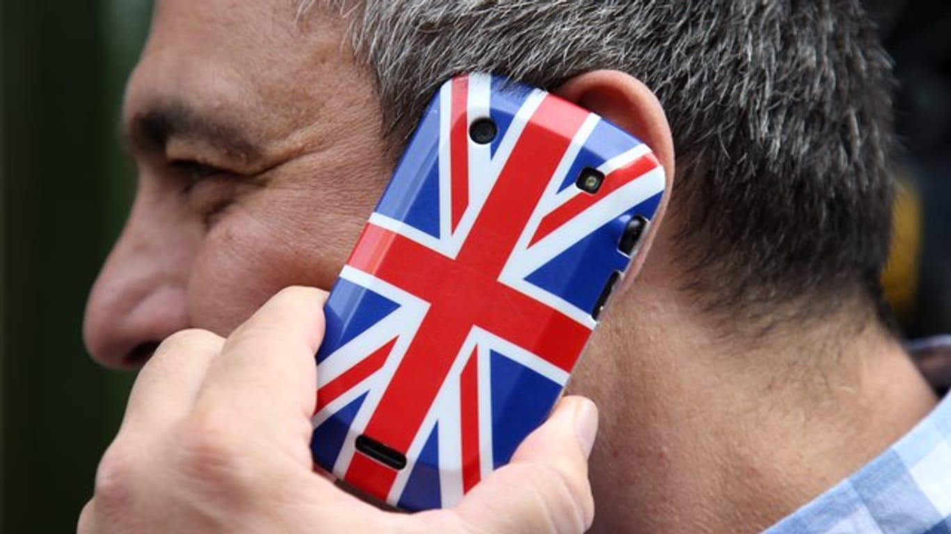 Mann telefoniert: Auch im Fall eines ungeregelten Brexit wollen die drei größten deutschen Mobilfunk-Anbieter vorerst keine Roaming-Gebühren erheben.