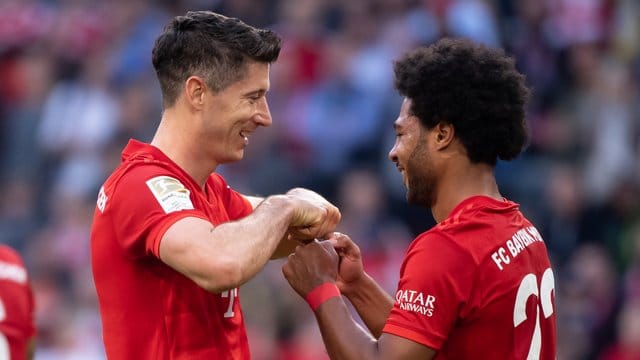 Serge Gnabry (r) gratuliert seinem Bayern-Kollegen Robert Lewandowski zum Torrekord.