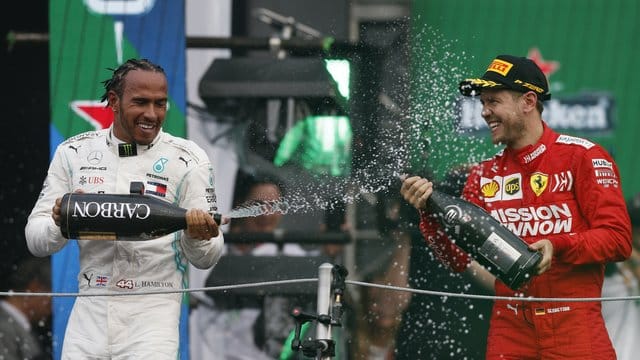 Champus für den Sieger: Lewis Hamilton feiert, Sebastian Vettel zwangsläufig mit.