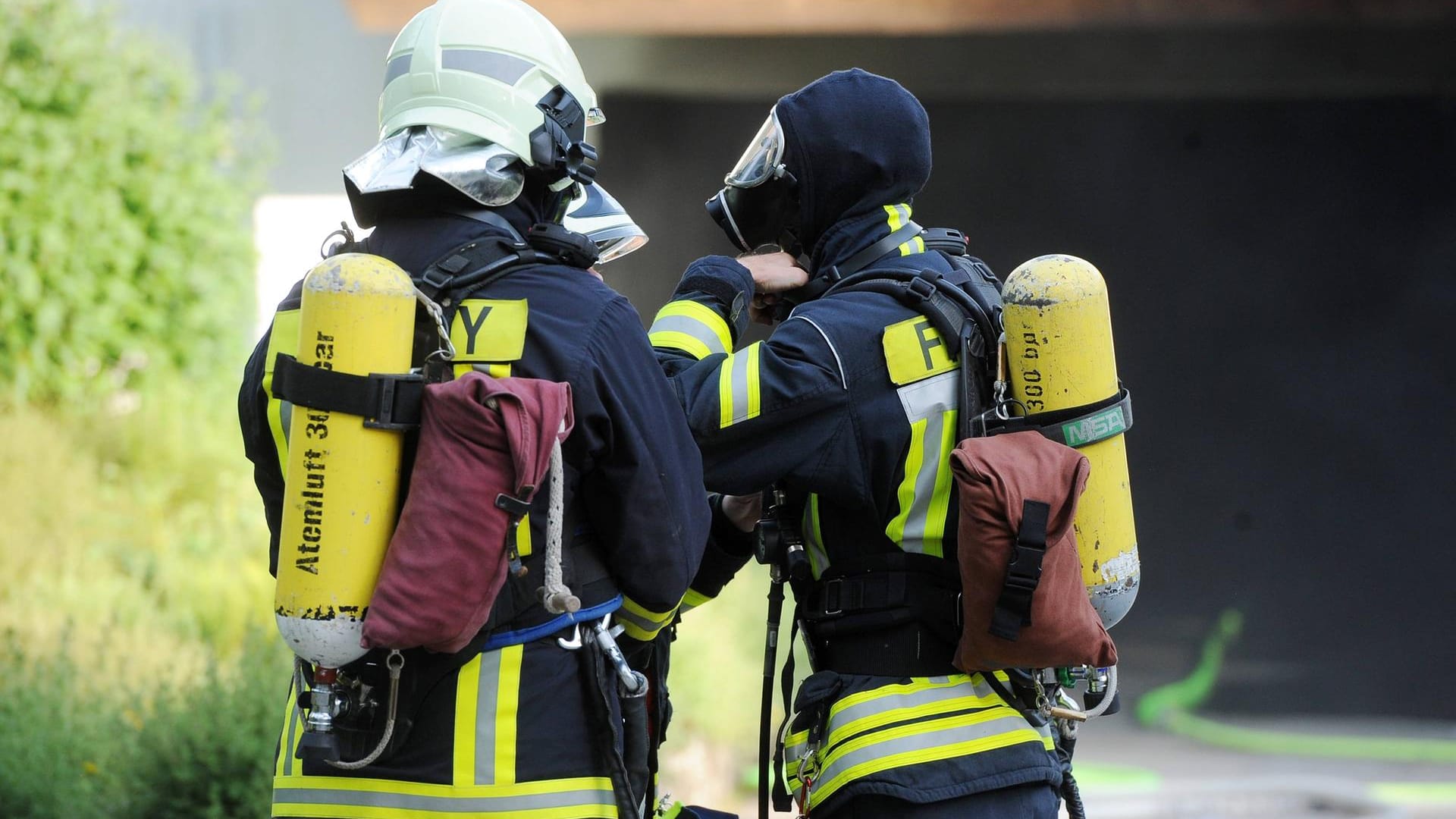 Zwei Feuerwehrleute mit Atemschutz und Sauerstofftanks: Am Sonntag haben Unbekannte einen Pkw in Brand gesetzt. Zwei Feuerwehrleute mit Atemschutz und Sauerstofftanks: Am Sonntag haben Unbekannte einen Pkw in Brand gesetzt.