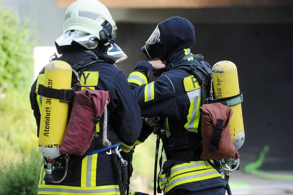 Zwei Feuerwehrleute mit Atemschutz und Sauerstofftanks: Am Sonntag haben Unbekannte einen Pkw in Brand gesetzt.