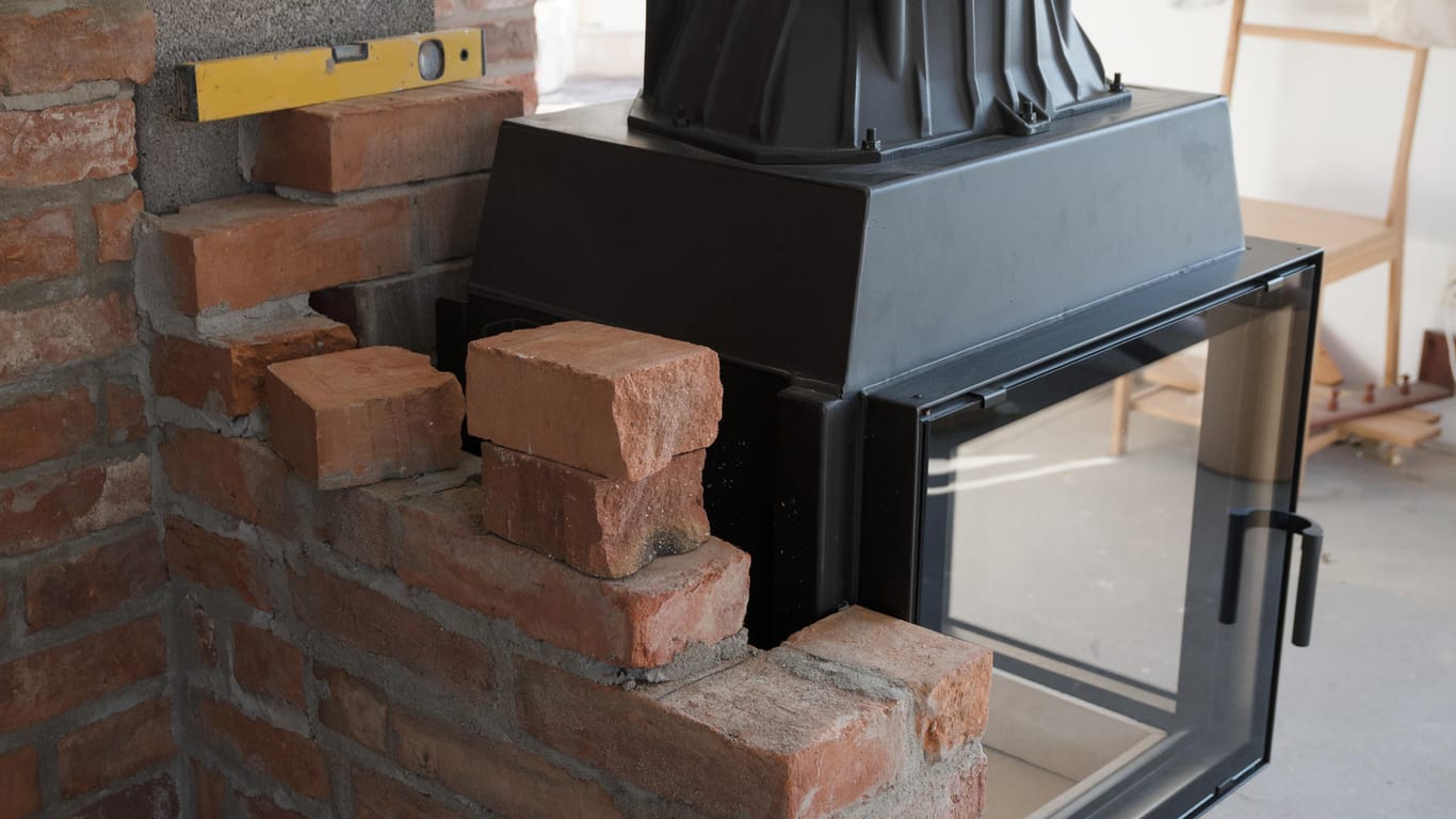 Halb eingemauerter Ofen: Die Abgasmündung des Schornsteins muss mindestens 15 Meter von den Fenstern und dem Dachaufbau der Nachbarn entfernt sein, um sie vor Rauch zu schützen.