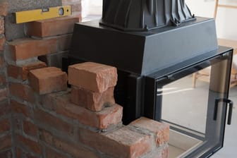 Halb eingemauerter Ofen: Die Abgasmündung des Schornsteins muss mindestens 15 Meter von den Fenstern und dem Dachaufbau der Nachbarn entfernt sein, um sie vor Rauch zu schützen.