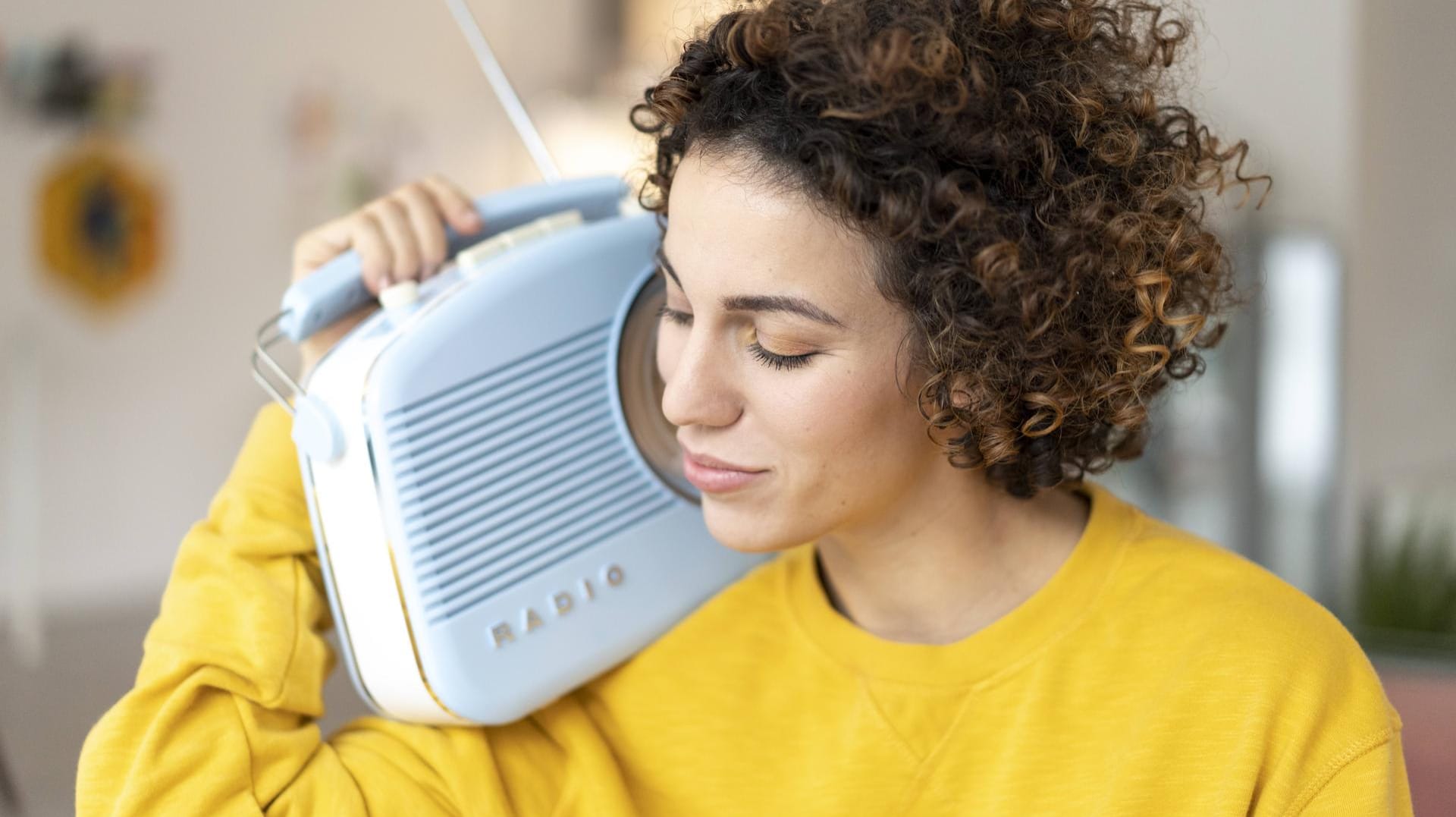 Woman listening to music with portable radio at home model released Symbolfoto property released PUB Woman listening to music with portable radio at home model released Symbolfoto property released PUB