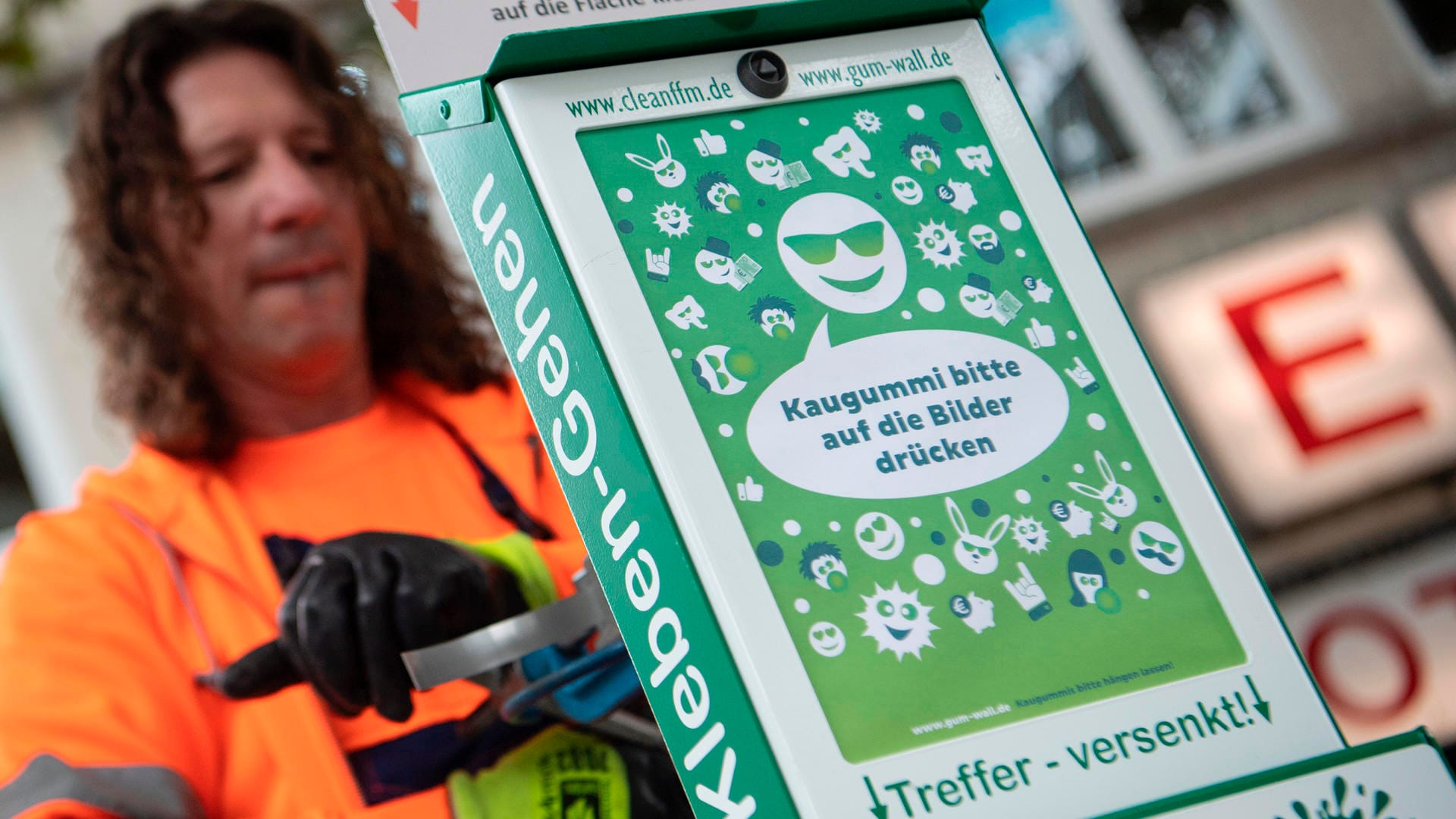 Ein Mitarbeiter der Stadtreinigung montiert eine "Gum-Wall": Die Stadt Frankfurt will gegen Kaugummi-Dreck auf der Straße vorgehen.
