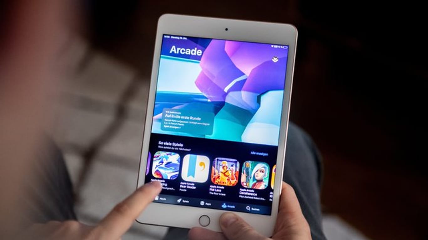 Ein Mann benutzt den Spiele-Abo-Dienst Apple Arcade auf einem iPad.
