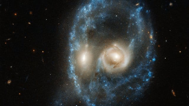 Die beiden verschmelzenden Galaxien wirken wie ein kosmisches Gesicht. Die beiden verschmelzenden Galaxien wirken wie ein kosmisches Gesicht.