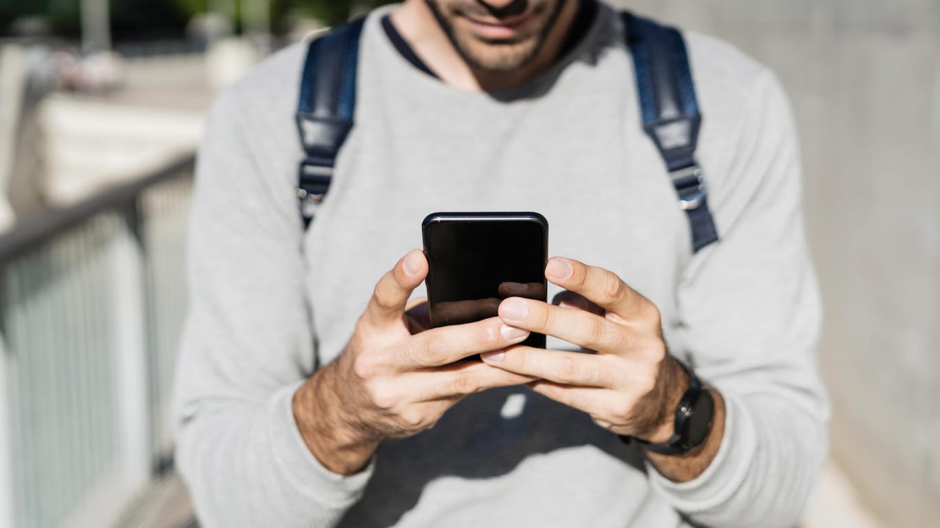 Ein Mann nutzt ein Smartphone: In Mainz ist ein 26-Jähriger in eine Betrugsfalle via App getappt.