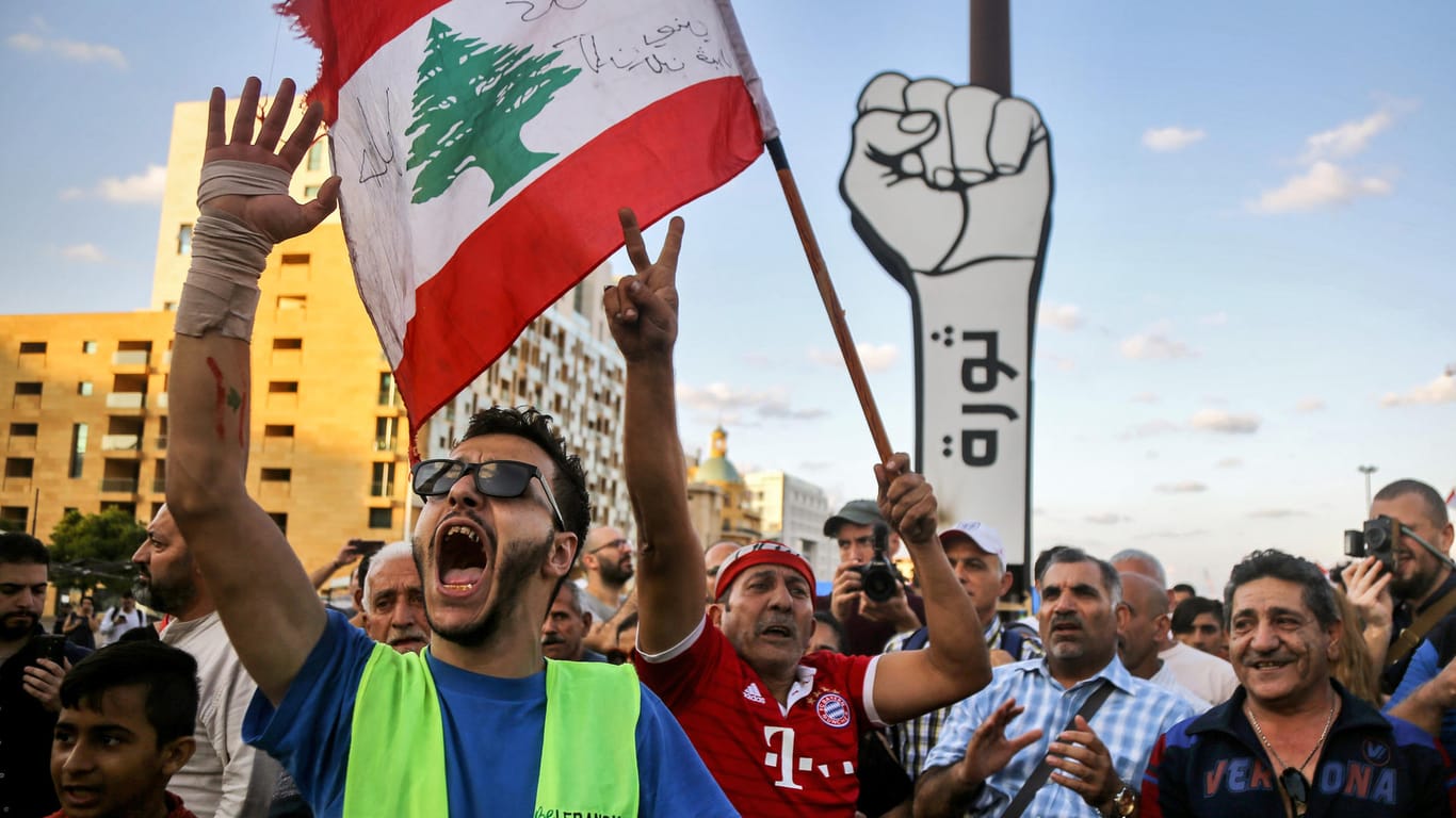 Beirut: Ein Demonstrant schwenkt auf dem Märtyrerplatz während eines Protestmarsches die libanesische Flagge. Wegen der anhaltenden Proteste gegen Korruption und Misswirtschaft hat Ministerpräsident Hariri seinen Rücktritt angekündigt.