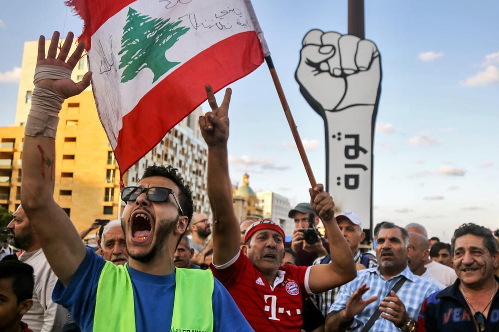 Beirut: Ein Demonstrant schwenkt auf dem Märtyrerplatz während eines Protestmarsches die libanesische Flagge. Wegen der anhaltenden Proteste gegen Korruption und Misswirtschaft hat Ministerpräsident Hariri seinen Rücktritt angekündigt.