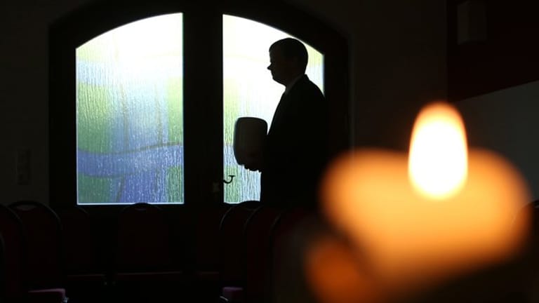 Ein Mann vor einer Kirchentür: Trauernden kann es helfen, nicht alles alleine entscheiden zu müssen.