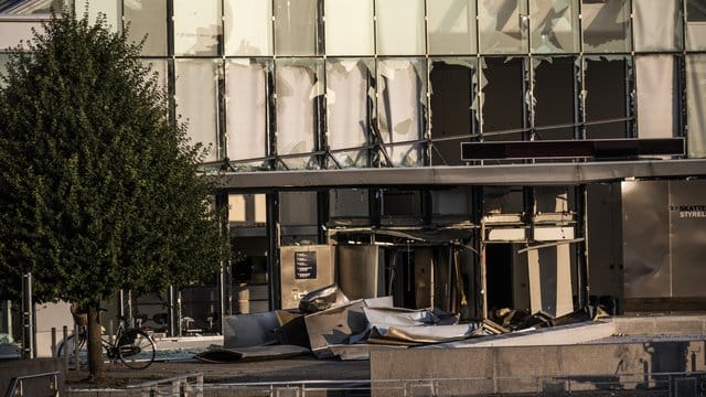 Glasreste zerbrochener Fensterscheiben, die durch eine Explosion am Eingang der dänischen Steuerbehörde zerstört wurden, hängen noch in den Fensterrahmen.