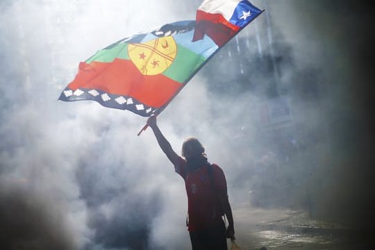 Ein vermummter Demonstrant weht die Flagge von Chile und der indigenen Gemeinschaft Mapuche mitten im Rauch während eines Protestes für Sozialreformen.