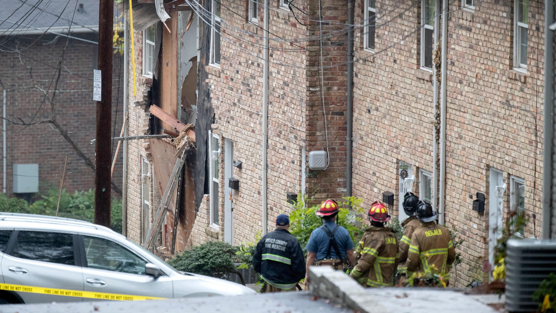 Rettungskräfte vor dem Haus, in das das Flugzeug hineinkrachte: Einer der zwei Fluginsassen starb bei dem Unglück.