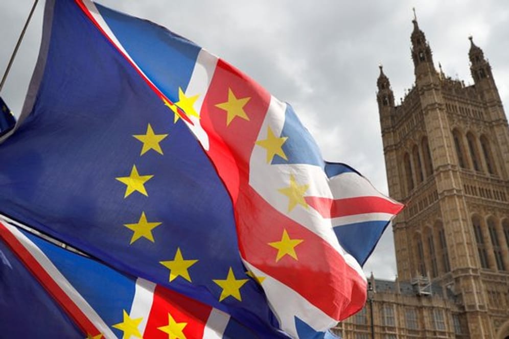 Fahnen, die jeweils zur Hälfte aus dem britischen Union Jack und der Flagge der Europäischen Union bestehen, vor dem Palace of Westminster.