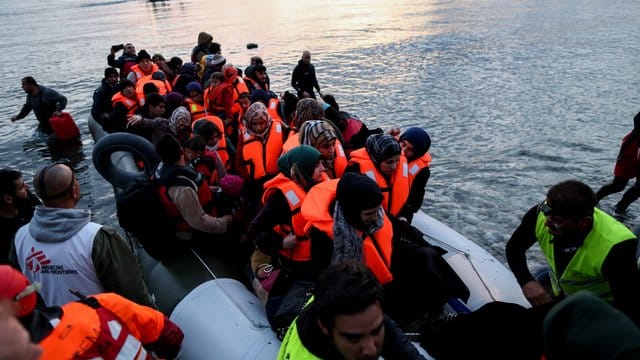 Freiwillige helfen auf der griechischen Insel Lesbos völlig erschöpften Flüchtlinge aus ihrem Boot. Freiwillige helfen auf der griechischen Insel Lesbos völlig erschöpften Flüchtlinge aus ihrem Boot.