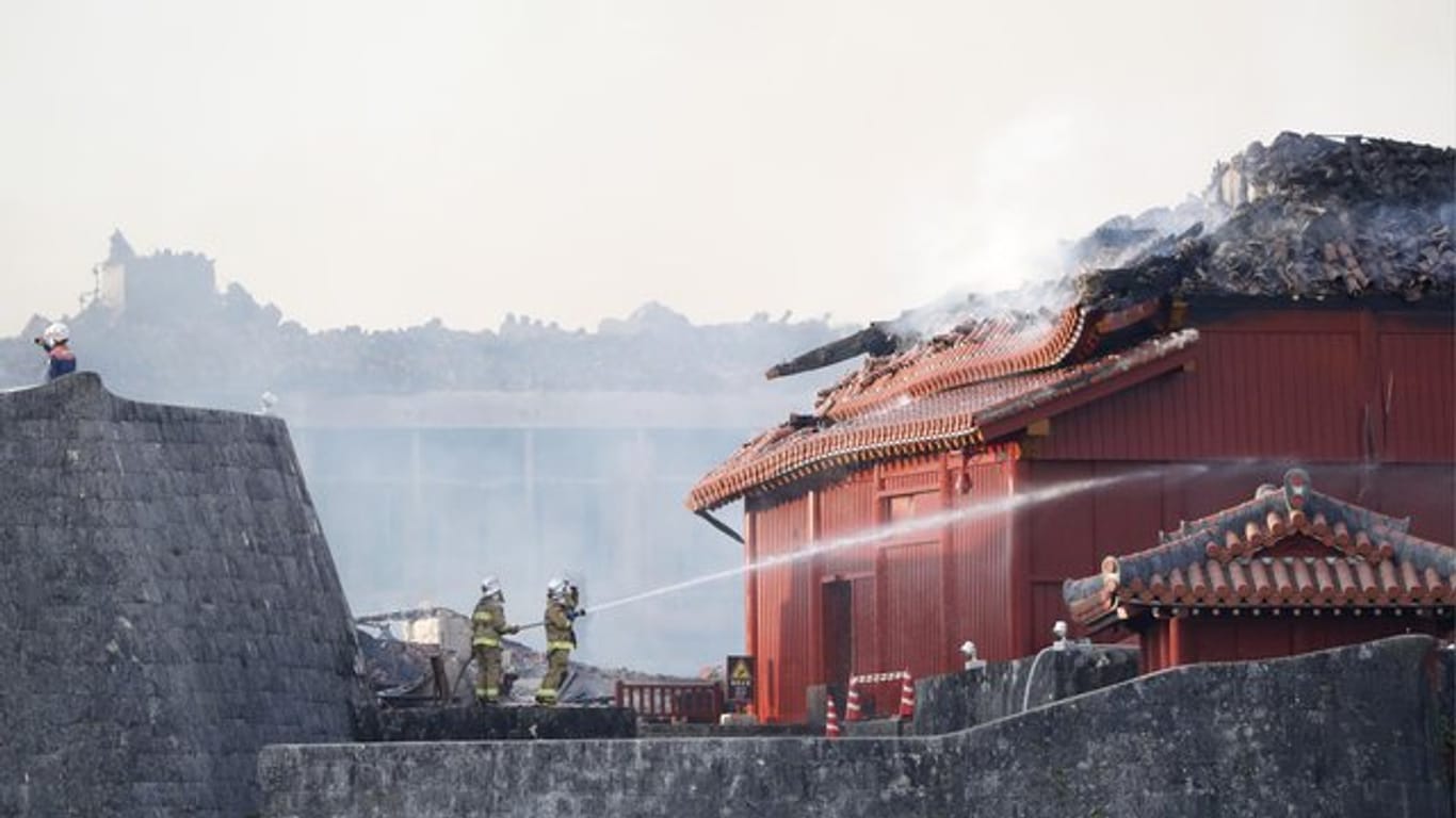 Feuerwehrleute versuchen einen Brand der historischen Shuri Burg zu löschen.