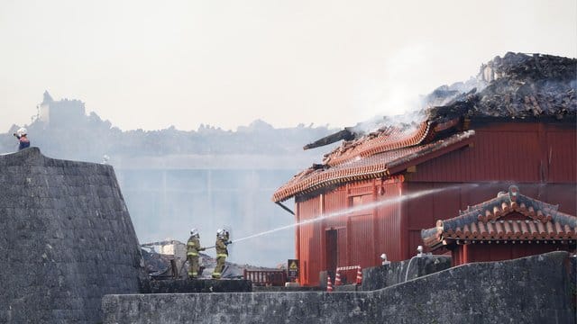 Feuerwehrleute versuchen einen Brand der historischen Shuri Burg zu löschen. Feuerwehrleute versuchen einen Brand der historischen Shuri Burg zu löschen.