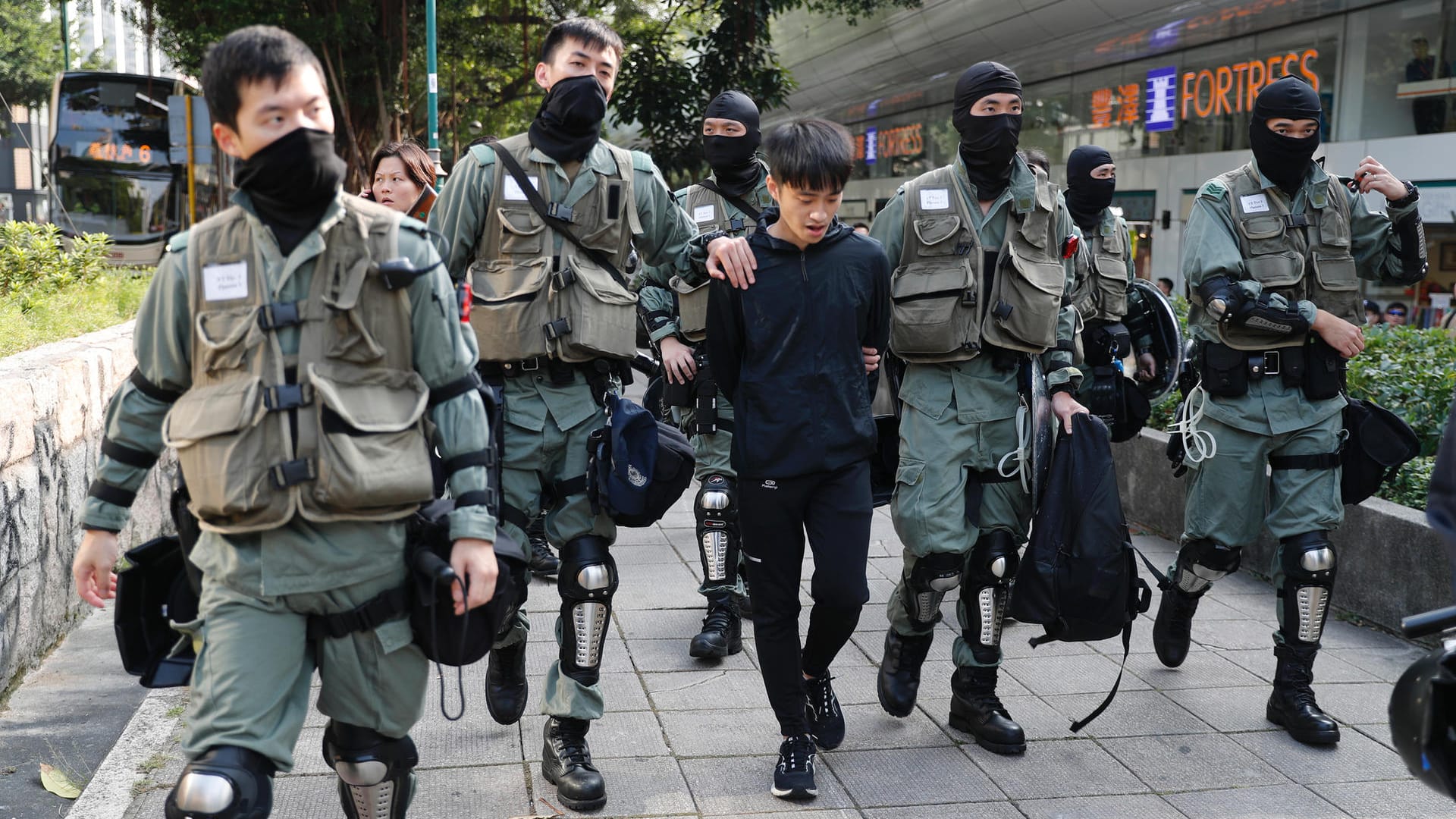 Polizisten in Hongkong nehmen einen Mann fest, nachdem sie eine Gasmaske bei ihm gefunden haben: In der Stadt herrscht Vermummungsverbot.