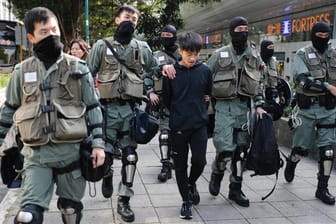 Polizisten in Hongkong nehmen einen Mann fest, nachdem sie eine Gasmaske bei ihm gefunden haben: In der Stadt herrscht Vermummungsverbot.