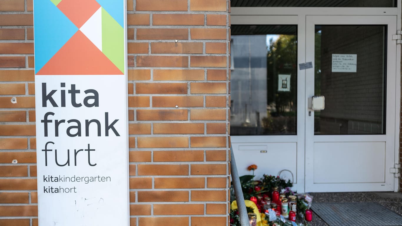 Blumen und Kerzen sind am Eingang einer Frankfurter Kita abgelegt: Ein Junge ist dort tödlich verletzt worden.
