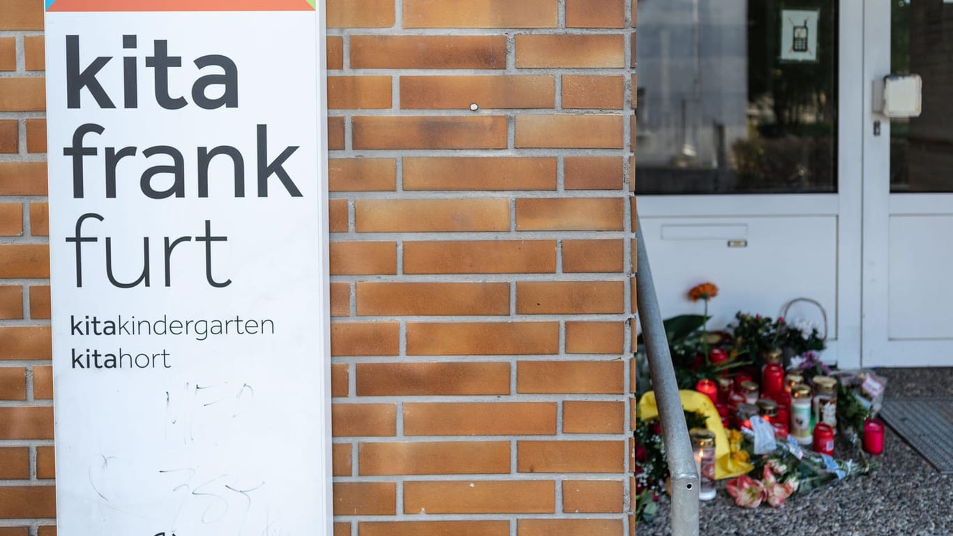 Blumen und Kerzen sind am Eingang einer Frankfurter Kita abgelegt: Ein Junge ist dort tödlich verletzt worden.