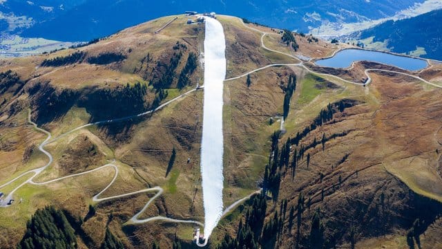 In den Kitzbüheler Alpen ist konservierter Schnee aus dem vergangenen Winter zu einer Piste zusammengeschoben worden. In den Kitzbüheler Alpen ist konservierter Schnee aus dem vergangenen Winter zu einer Piste zusammengeschoben worden.