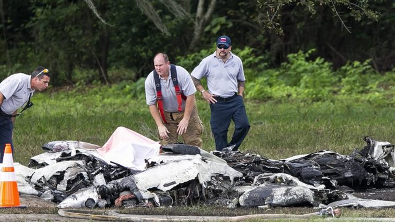 Rettungskräfte stehen neben dem abgestürzten Flugzeug in Ocala.
