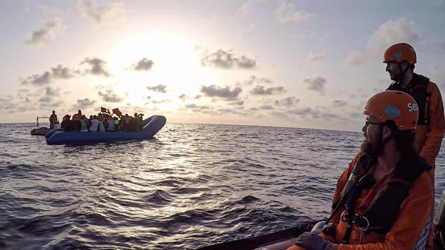 Seenotretter vom Rettungsschiff "Alan Kurdi" blicken zu einem Schlauchboot voller Flüchtlinge (Archiv).