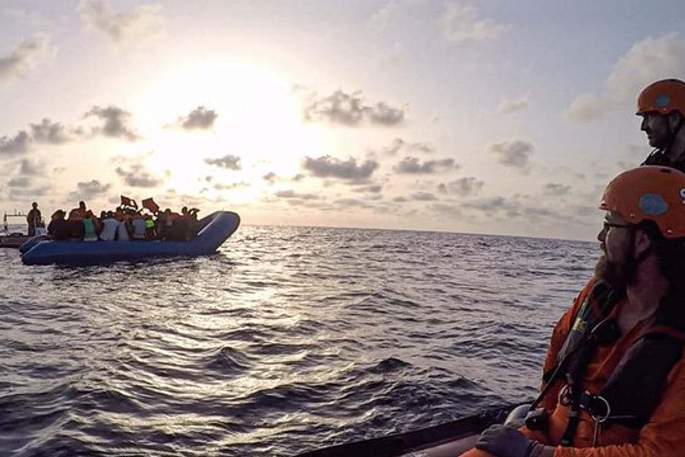 Seenotretter vom Rettungsschiff "Alan Kurdi" blicken zu einem Schlauchboot voller Flüchtlinge (Archiv).